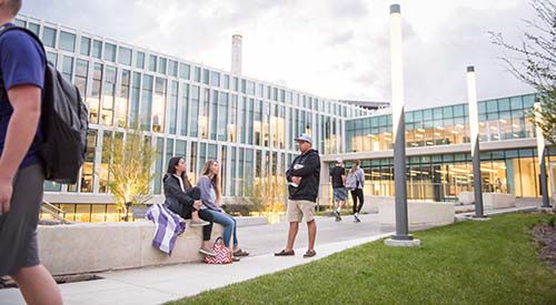 K-State students sitting outside campus buildings